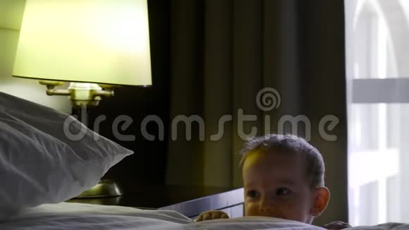 一个小男孩唤醒了父母与他们调情小可爱的宝贝和站在床边的父母玩4k视频的预览图