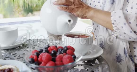 成熟的女人把柠檬茶倒在杯子里视频的预览图