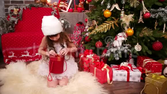 带着新年礼物的快乐孩子穿着雪少女服装的小女孩的特写带着礼物的圣诞快乐假期视频的预览图