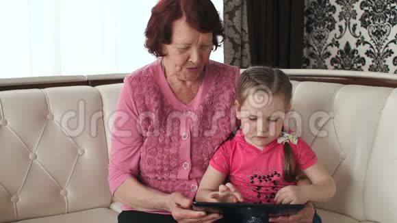小女孩和奶奶玩平板电脑视频的预览图