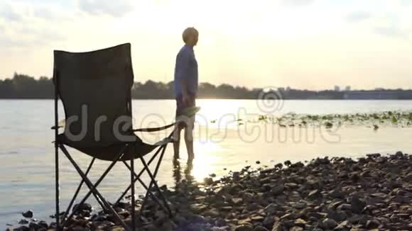 光着脚站在河岸边的水中留下一块石头视频的预览图