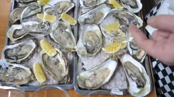 许多牡蛎用柠檬水果装饰在冰盘上视频的预览图
