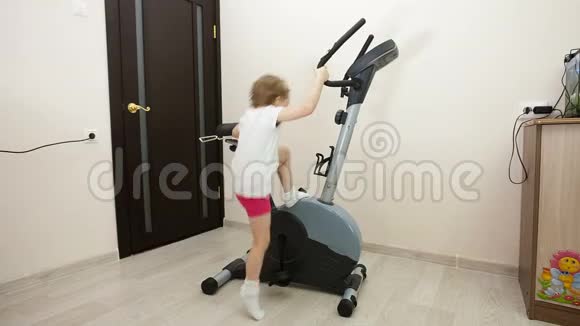 小女孩在房间里骑自行车锻炼视频的预览图