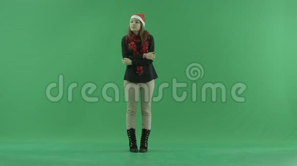 年轻女子冷冻并试图保持自己温暖绿色的关键背景视频的预览图