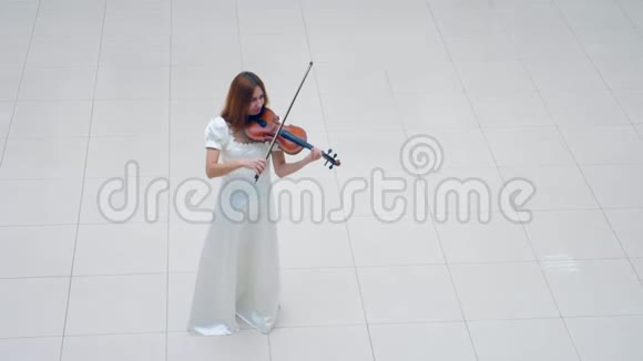 小提琴手女士正穿着白色连衣裙演奏乐器视频的预览图