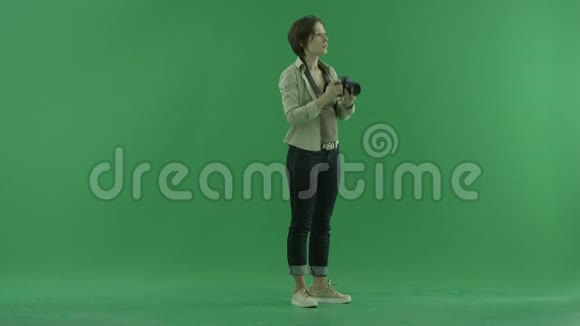 一位年轻女子正在绿色屏幕的右手边拍照视频的预览图
