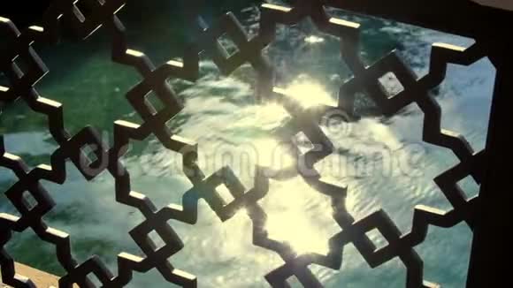 透过一个美丽的露天格子你可以看到水面上的阳光特写镜头视频的预览图