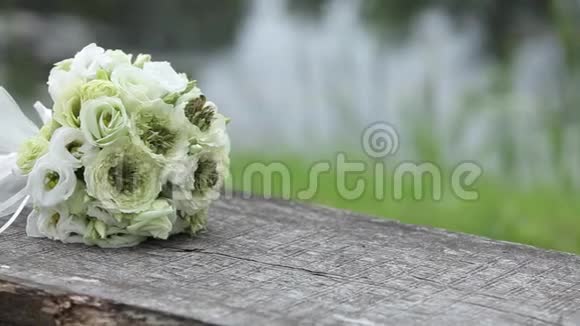 在户外木制长凳上放白色婚礼花束视频的预览图