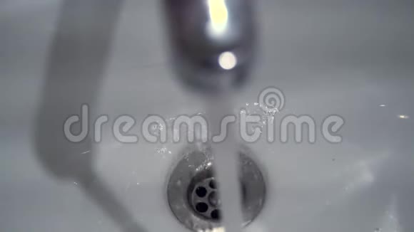 水从水龙头流入水槽水从水龙头滴到水槽里从顶部看特写镜头视频的预览图