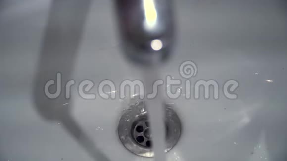 水从水龙头流入水槽水从水龙头滴到水槽里从顶部看特写镜头视频的预览图