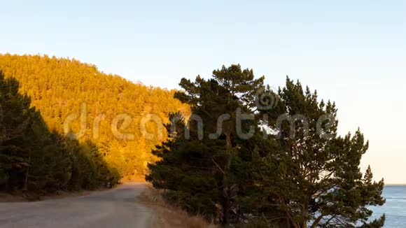 贝加尔湖海岸风光乡村道路树木山日落时间流逝视频的预览图