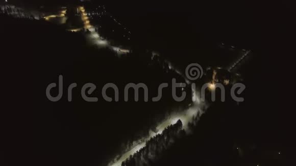 夜间林区冬季道路俯视图剪辑白雪皑皑的道路在夜里被灯笼照亮视频的预览图