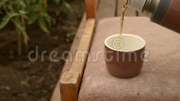 花园里倒着茶的热水瓶视频的预览图