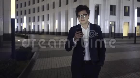 年轻商人在夜城散步时上网视频的预览图