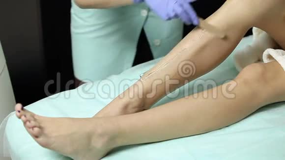 美容师在脱毛前用凝胶病人的脚视频的预览图