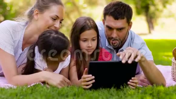 夏季公园野餐时带平板电脑的家庭视频的预览图