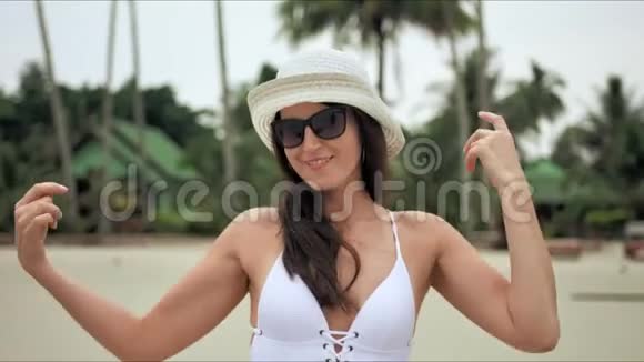 年轻漂亮的女人在海滩上享受暑假和跳舞视频的预览图