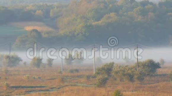美丽的风景雾蒙蒙的村庄平原秋雾背景下的电力线路视频的预览图