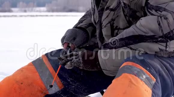 渔夫在冰上钓到一条鱼冰上钓鱼视频的预览图