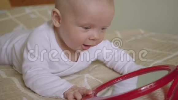 美丽的婴儿玩镜子亲吻他的倒影六个月大的婴儿视频的预览图