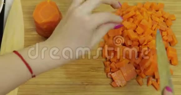 女家庭主妇用手把胡萝卜切成碎片视频的预览图