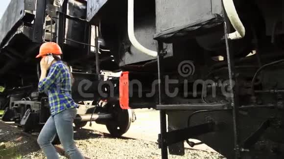一个年轻的女火车司机走在火车旁边视频的预览图