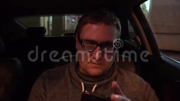 年轻的帅哥在车里用手机视频的预览图