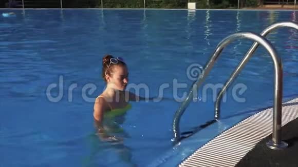 一个身材好的漂亮女人从室外游泳池里走出来视频的预览图