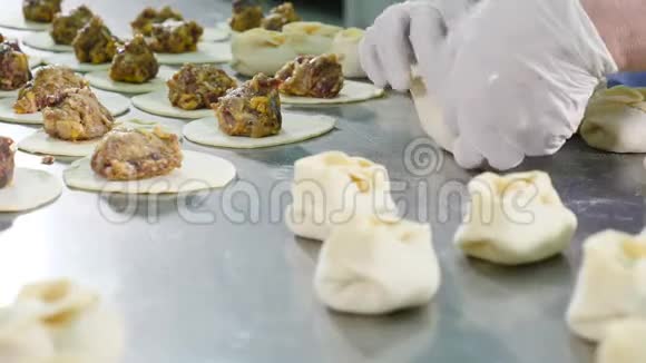 在肉厂做肉饺子女工戴白色乳胶手套统一用面团包肉肉类厂视频的预览图
