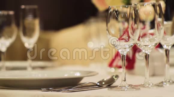 酒杯的特写场景在优雅的餐厅里以美丽的花束为背景的空酒杯视频的预览图