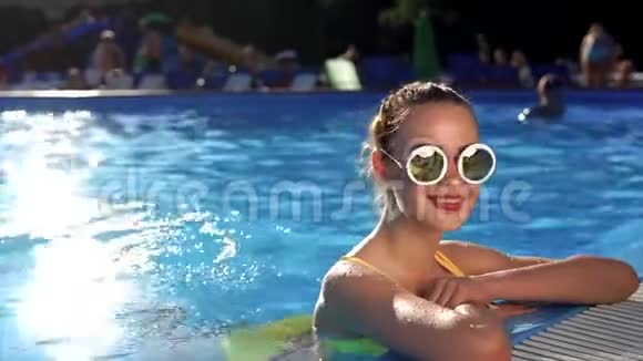 优雅的女人在游泳池里休息喜欢在水里游泳夏天休息视频的预览图