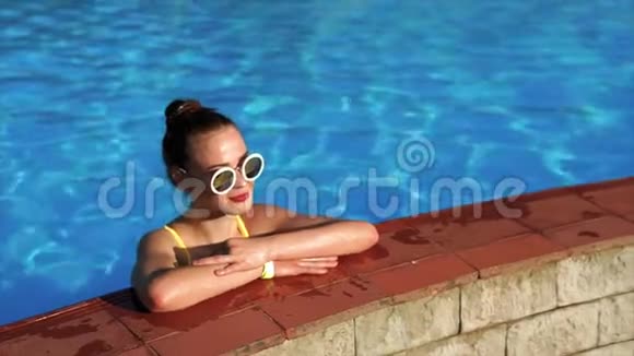 漂亮的女人站在游泳池旁边享受假期视频的预览图