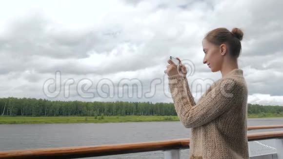 女用智能手机在游轮甲板上拍照视频的预览图