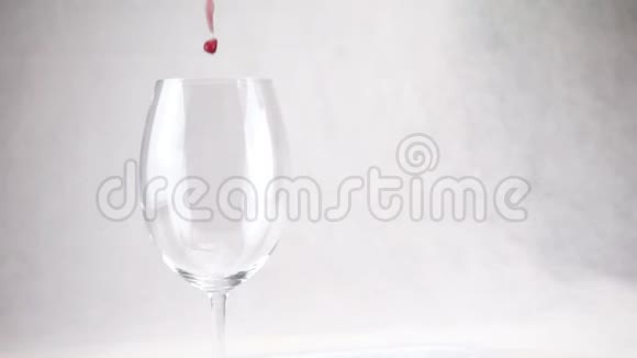 红酒正倒入白色背景上的玻璃杯中慢动作视频的预览图