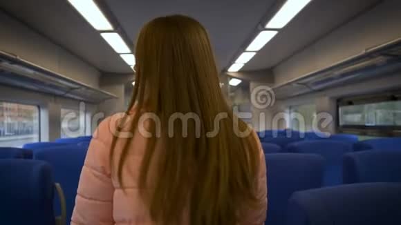 年轻漂亮的女人在火车上带眼镜长发粉色夹克视频的预览图