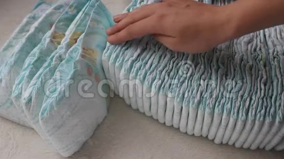 女孩拿着她的手在一堆婴儿尿布特写视频的预览图