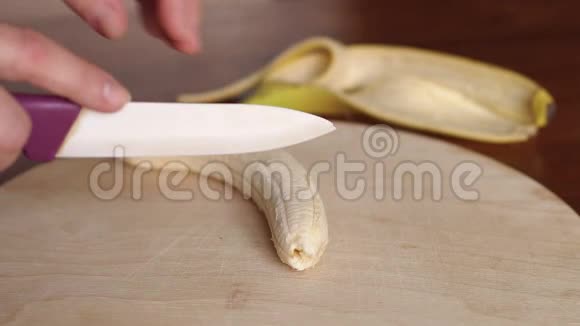 在切割板上切香蕉的女人特写视频的预览图