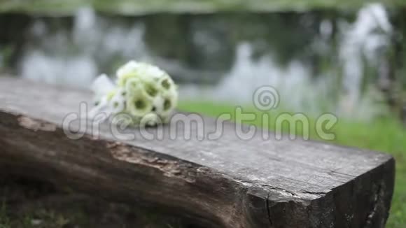 在户外木制长凳上放白色婚礼花束视频的预览图