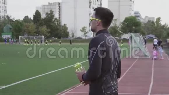 主题体育与健康年轻的高加索男性运动员在一个城市体育场的运动瓶里饮水视频的预览图