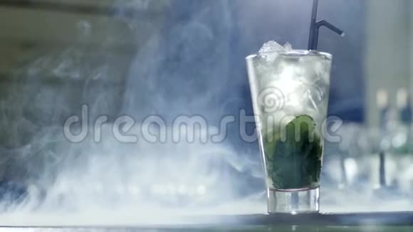 用冰块和绿色植物在透明玻璃中冷却饮料用黑色塑料吸管站在雾条上视频的预览图