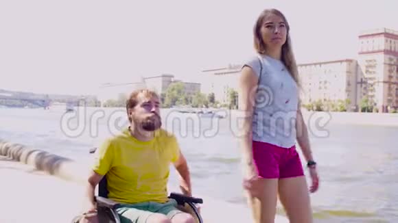 年轻的残疾人和妻子在河边散步视频的预览图