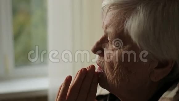 老年祈祷妇女的肖像视频的预览图