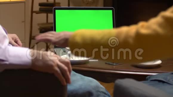 一对老年夫妇在带绿色屏幕的笔记本电脑上看电视剧视频的预览图
