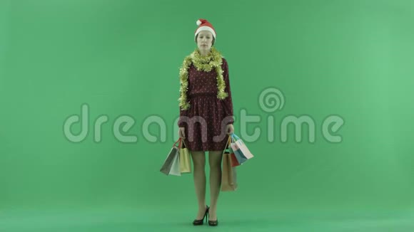 一位年轻女孩正在绿色屏幕上为观众展示圣诞节购物的结果视频的预览图