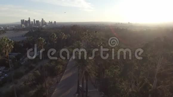 惊人的空中无人机剪辑洛杉矶和阳光背后的公园树视频的预览图