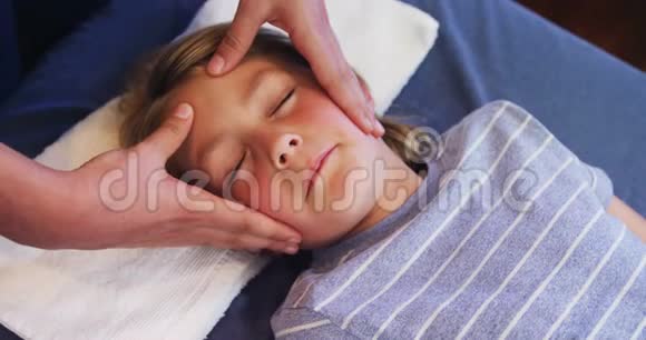 理疗师给一个男孩做头部按摩视频的预览图