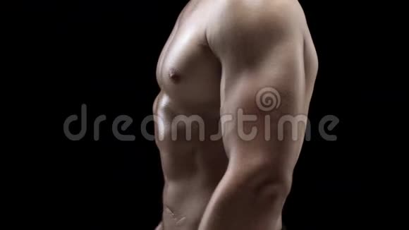 男人在黑色背景下展现肌肉强健的身体特写视频的预览图