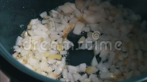在热沸油中炒洋葱煎锅的特写烹饪蔬菜视频的预览图