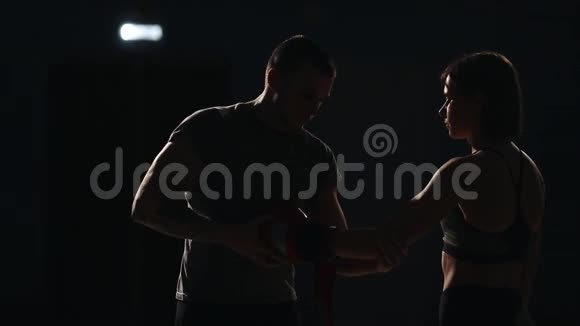 教练在战斗前给拳击手的女孩戴上拳击手套为比赛做准备视频的预览图