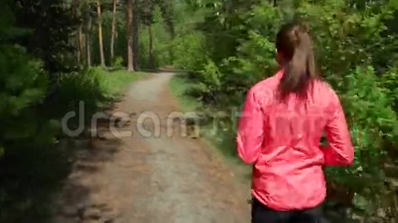 户外健身运动运动女人穿过树林她心情很好身材很好落叶视频的预览图